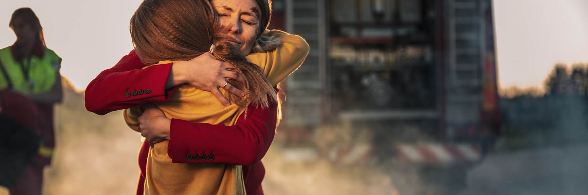 Car Crash Traffic Accident: Injured Young Girl Reunites with Her Loving Mother. In the Background Fire engine and Courageous Paramedics and Firemen Save Lives