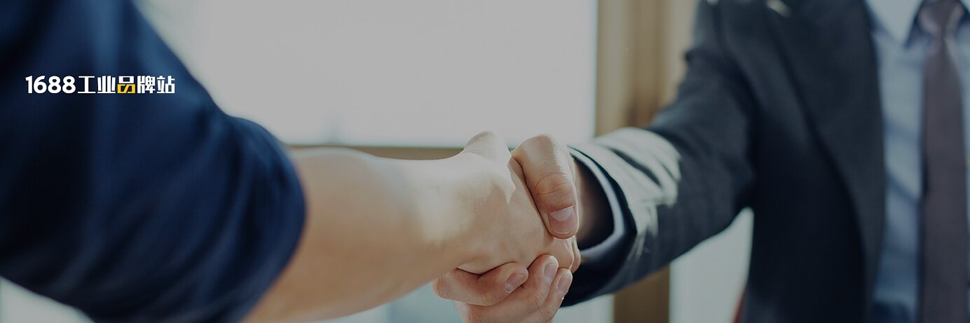 Two people are shaking hands over a desk with documents, charts, and a tablet on it. Both are dressed in business attire. The lighting suggests a daytime office setting. (This text has been generated by AI)